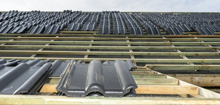 Roof ceramic tile arranged in packets on the roof on roof battens. laying tiles on a boarded roof.